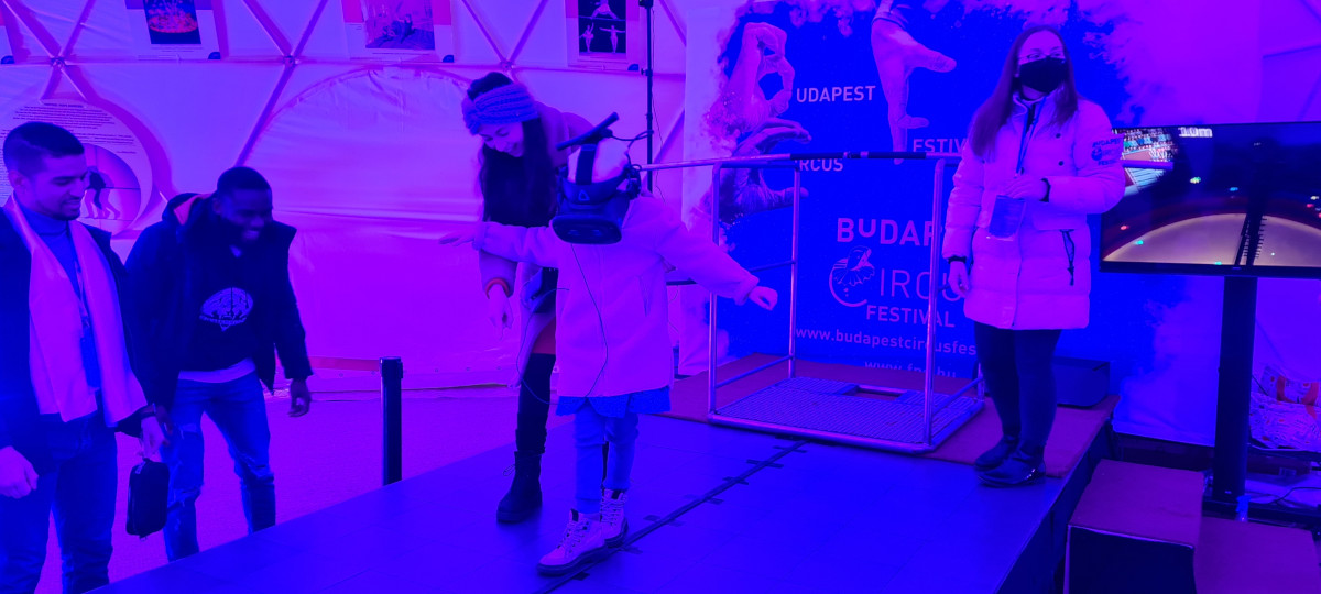child balancing in a VR headset in the tent of the 14th Budapest Circus Festival