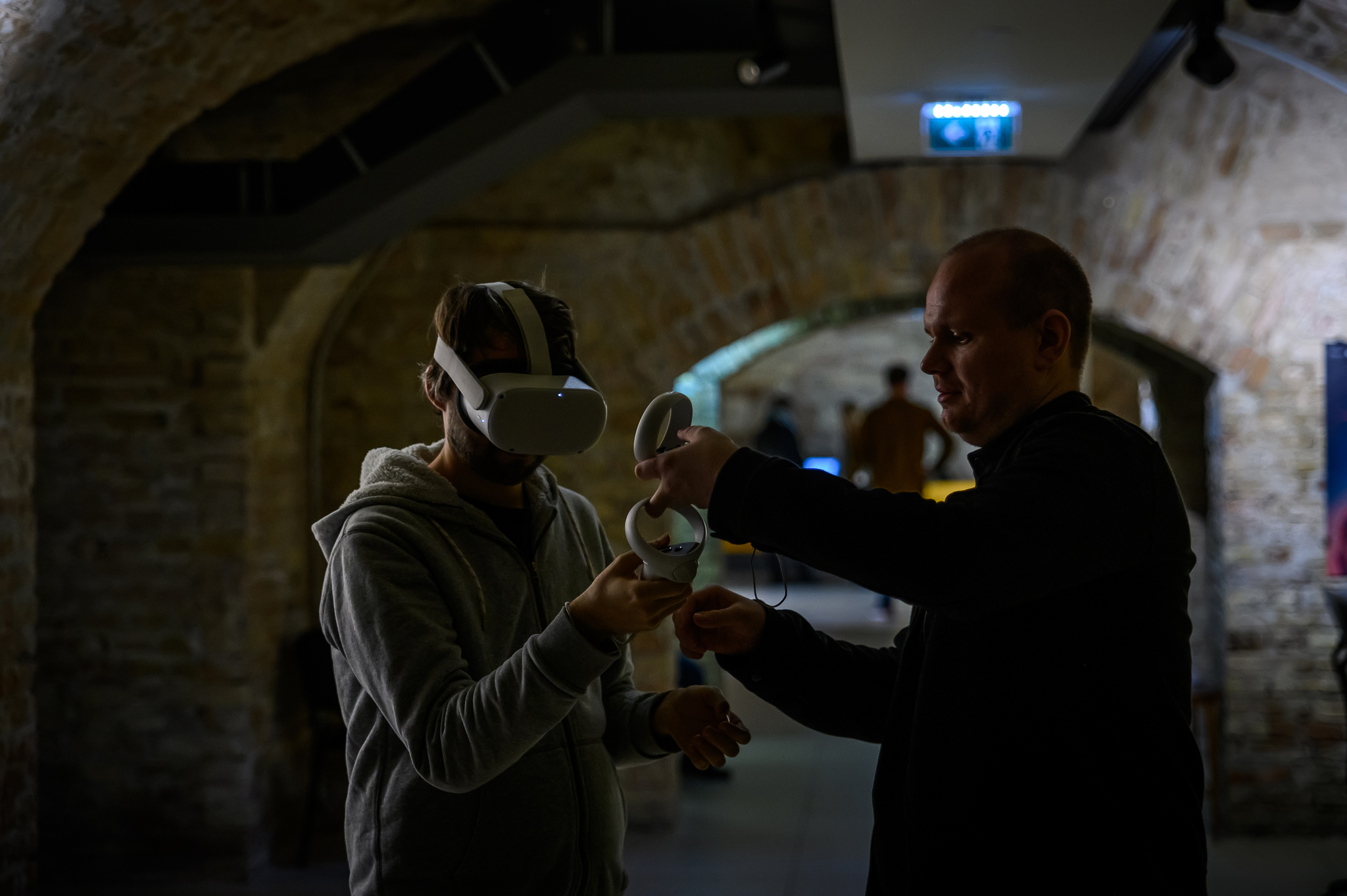 Man helping with VR devices to a participant of Vektor VR section vol.3.